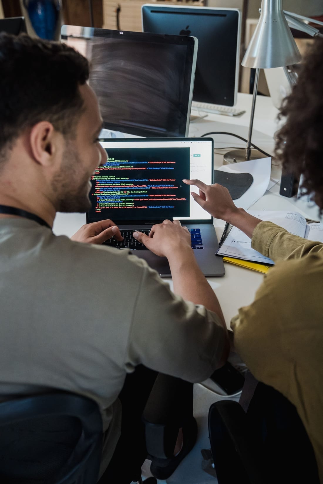 To udviklere gennemgår kode på en bærbar computer